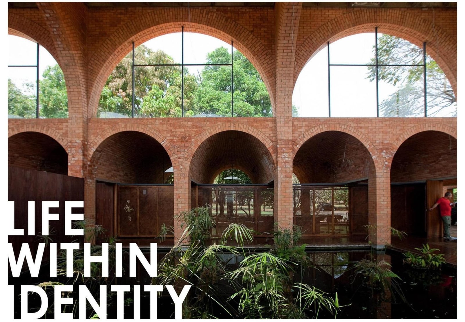 Brick courtyard reference image with large arched glazing and greenery.