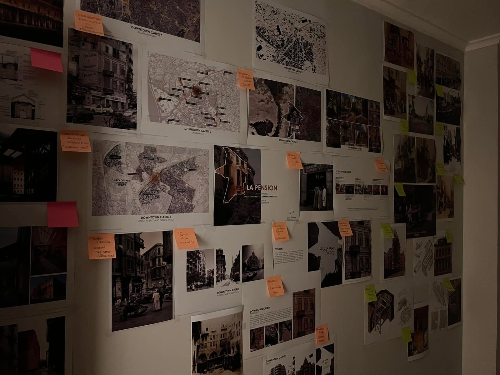Wide view along the La Pension research wall, showing maps and concept sheets alongside architectural photographs and colored notes.