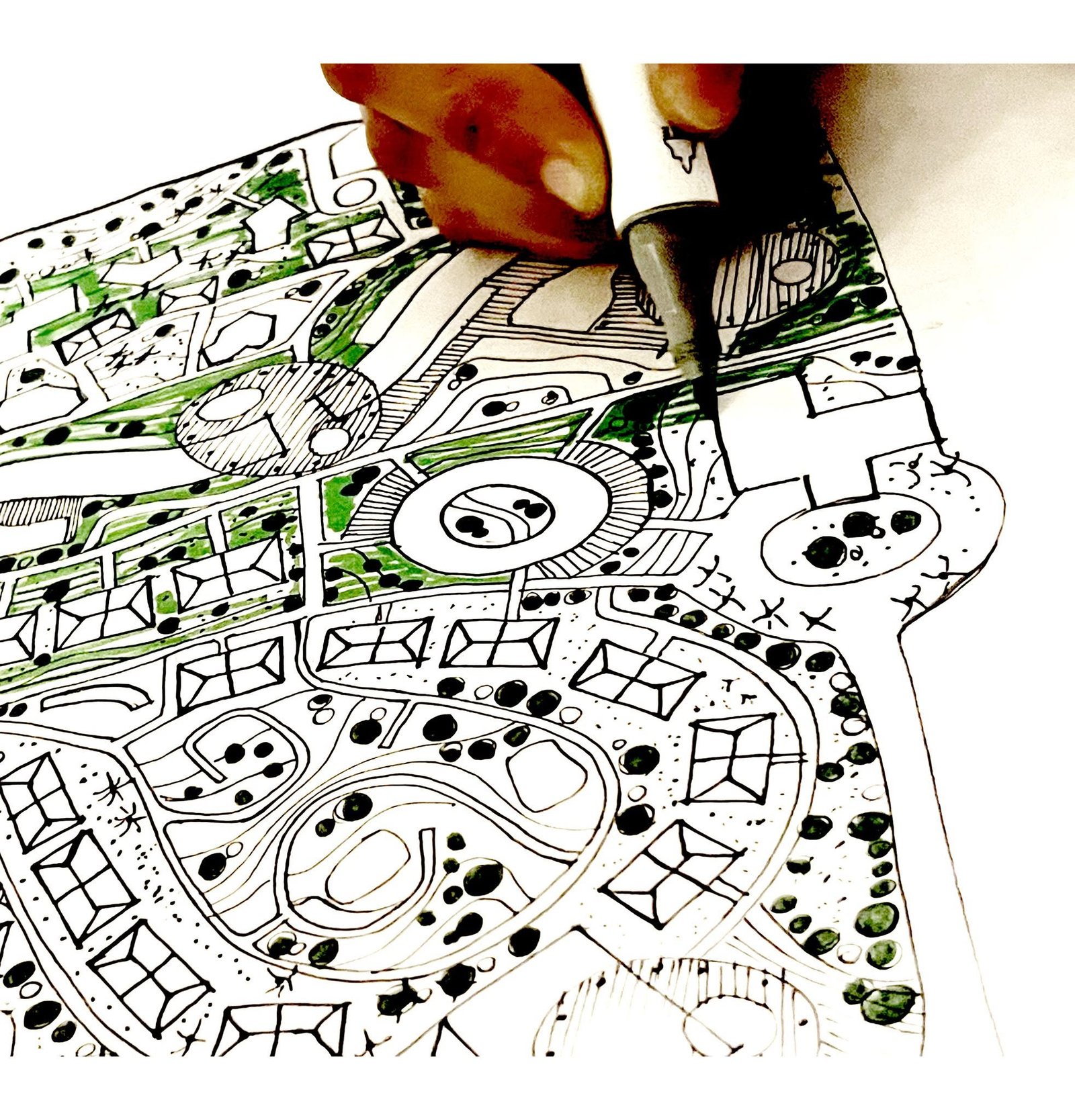 Close-up of a hand adding ink to a freehand Zanzibar master plan with curved paths, building outlines and green landscape areas.