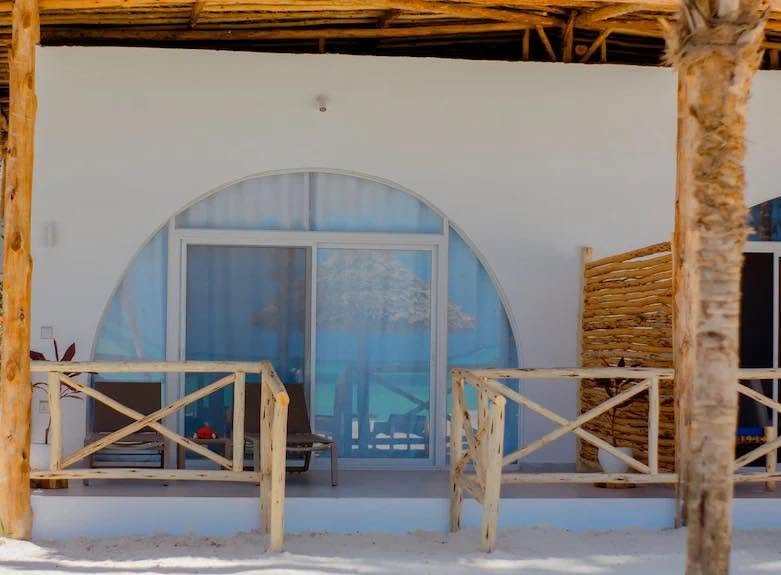 Royal Mandrine Resort site detail of an arched glazed room entrance behind a timber veranda railing.