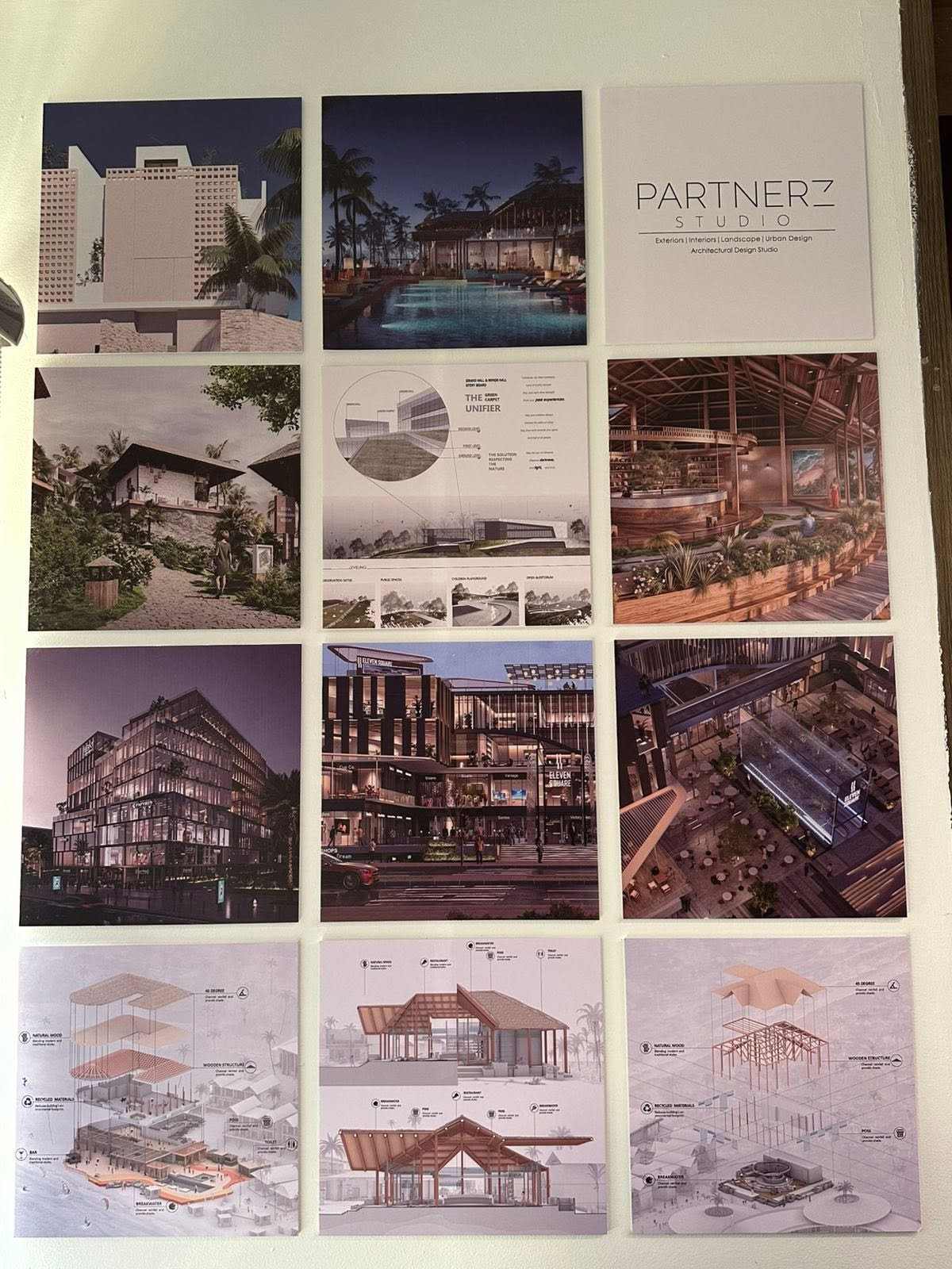 Partnerz studio display wall with architectural exterior and interior renderings, presentation drawings, and exploded building diagrams.