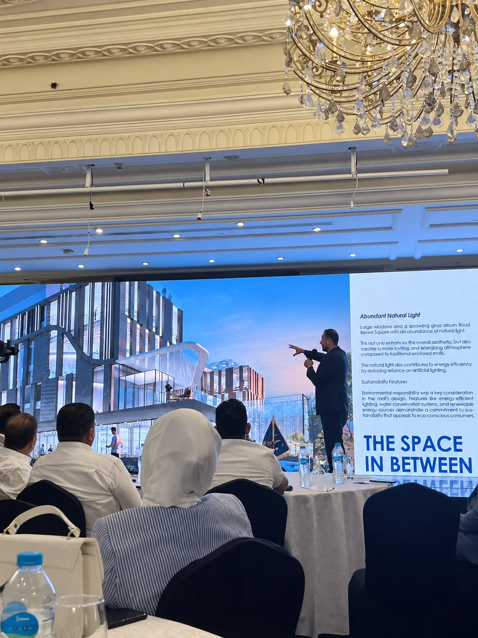An architectural presentation with a speaker and a large projected image.